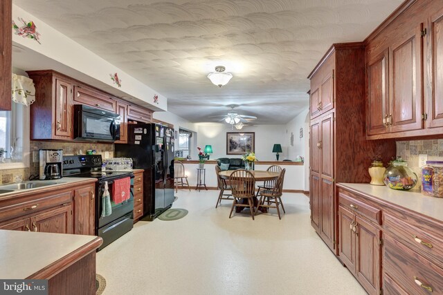 310 Updyke Rd, Littlestown, PA 17340 - kitchen with black appliances, backsplash, and healthy amount of natural light