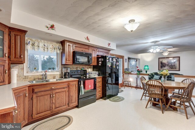 310 Updyke Rd, Littlestown, PA 17340 - kitchen with black appliances, a sink, decorative backsplash, ceiling fan, and brown cabinetry