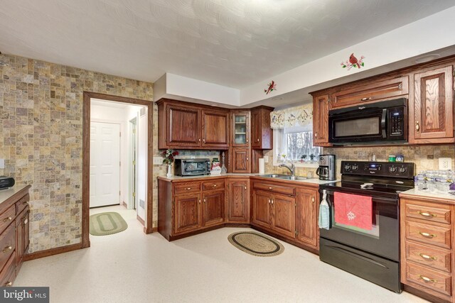 310 Updyke Rd, Littlestown, PA 17340 - kitchen with black appliances, a sink, light countertops, and brown cabinetry