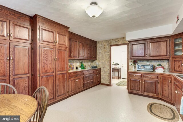 310 Updyke Rd, Littlestown, PA 17340 - kitchen with light countertops, baseboards, glass insert cabinets, and brown cabinets