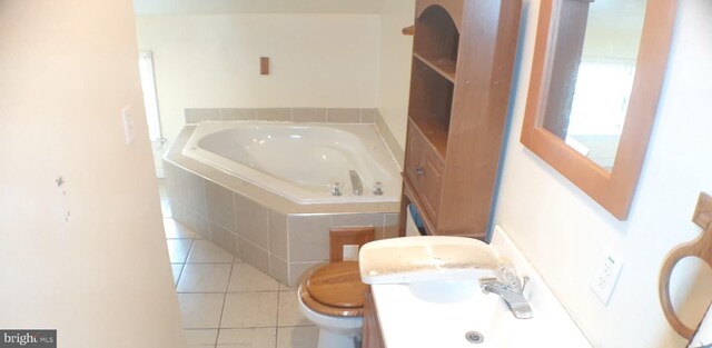 bathroom with tile patterned flooring, vanity, tiled bath, and toilet