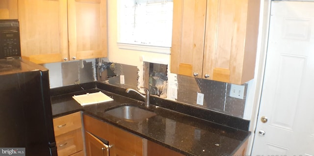 kitchen featuring dark stone countertops and sink