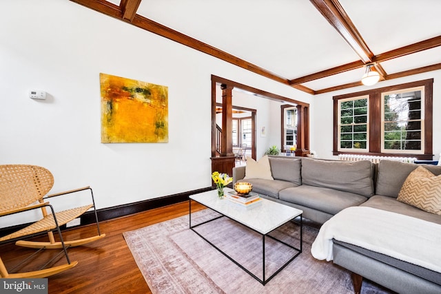 living room with beamed ceiling, wood-type flooring, and decorative columns