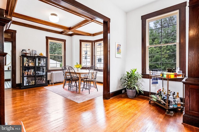 interior space featuring plenty of natural light, beamed ceiling, wood-type flooring, and coffered ceiling