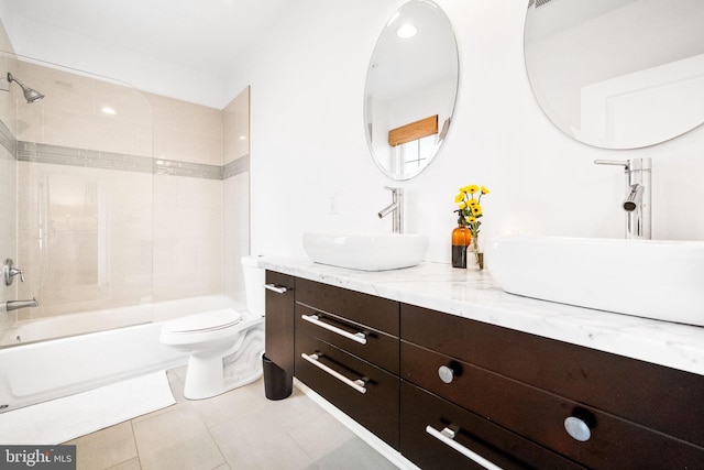 full bathroom featuring tile patterned flooring, vanity, toilet, and tiled shower / bath combo