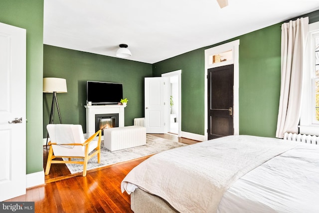 bedroom featuring hardwood / wood-style flooring and radiator