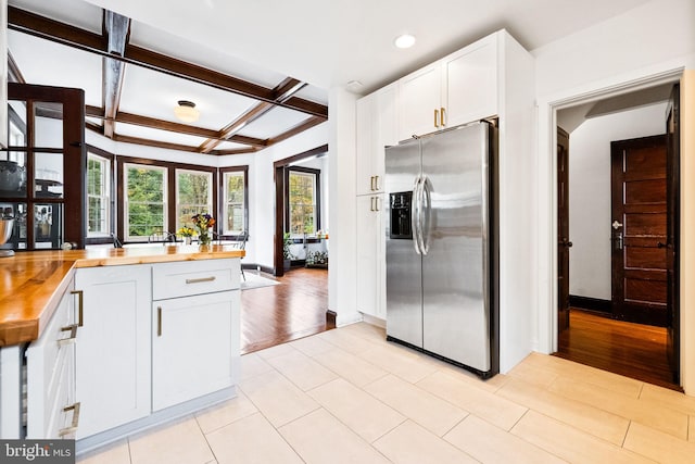 kitchen featuring stainless steel fridge with ice dispenser, white cabinetry, butcher block counters, and light hardwood / wood-style flooring