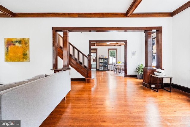 foyer featuring beamed ceiling, light hardwood / wood-style floors, and ornate columns