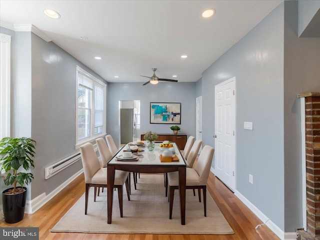 dining area featuring ceiling fan, light hardwood / wood-style flooring, and a baseboard radiator