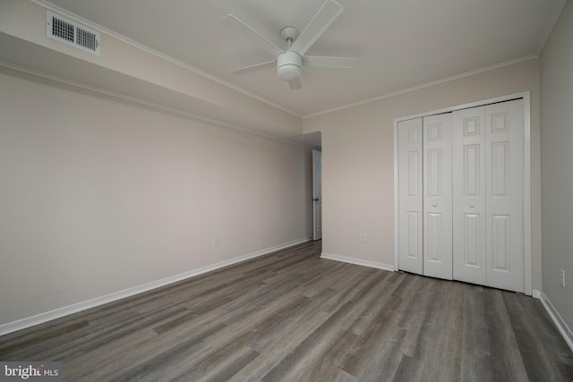 unfurnished bedroom with hardwood / wood-style floors, a closet, ceiling fan, and ornamental molding