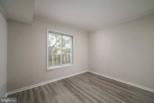 spare room with wood-type flooring and ornamental molding