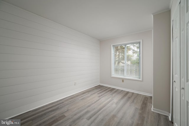 empty room with ornamental molding and light wood-type flooring