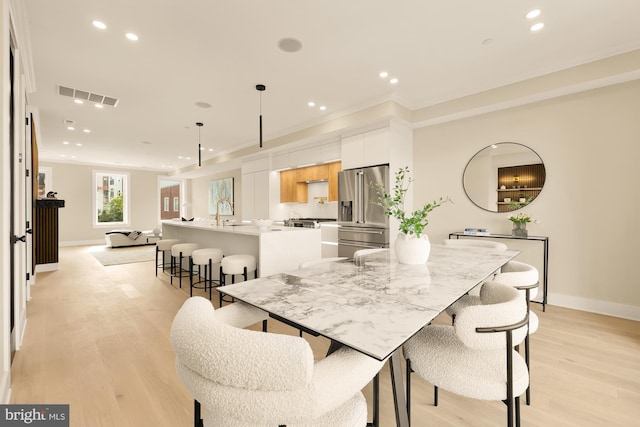 dining space featuring sink and light wood-type flooring