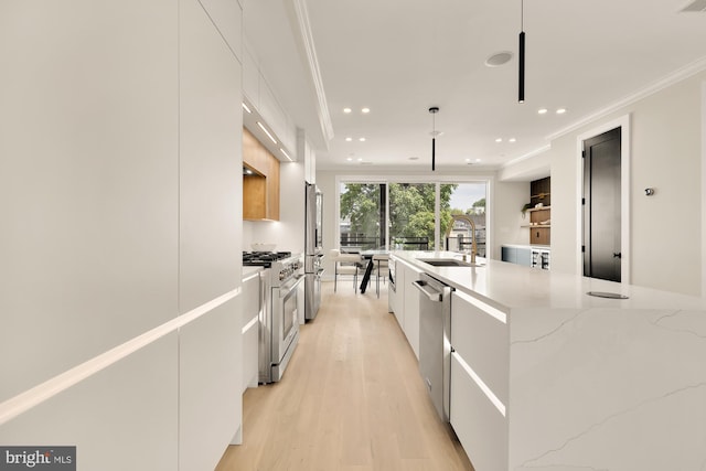 kitchen with pendant lighting, white cabinets, sink, a large island, and stainless steel appliances