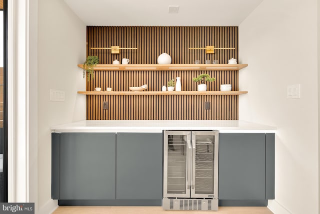 bar featuring gray cabinetry and beverage cooler