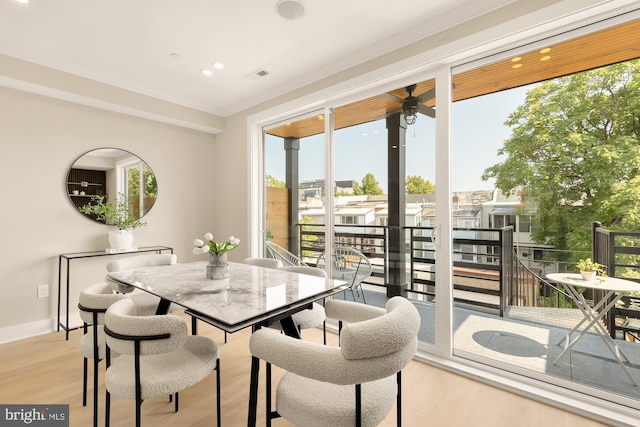 dining space featuring crown molding and light hardwood / wood-style floors