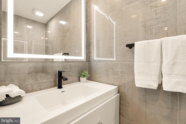 bathroom featuring backsplash, vanity, and tile walls