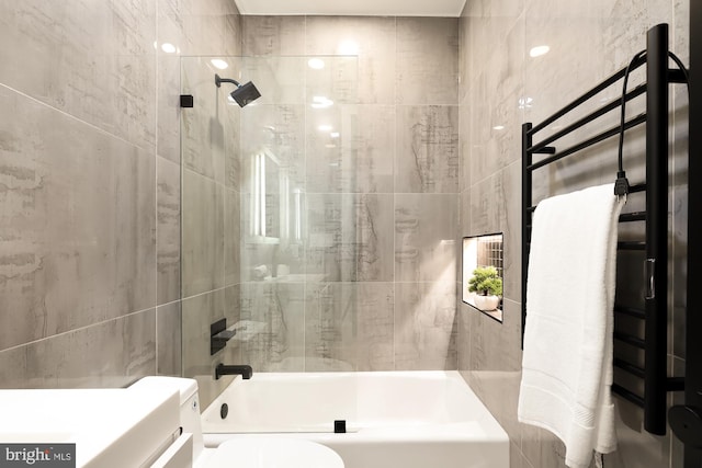 bathroom with toilet, tile walls, and bathtub / shower combination