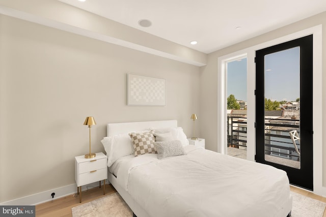 bedroom with access to exterior and light hardwood / wood-style flooring