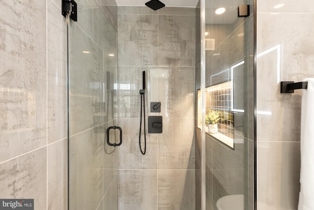 bathroom with a shower with door