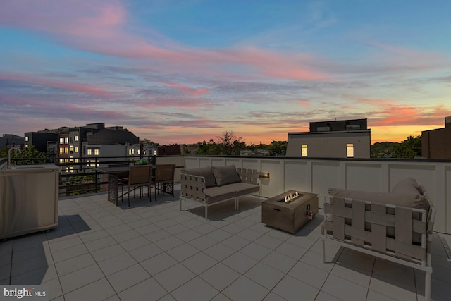 patio terrace at dusk featuring an outdoor living space with a fire pit