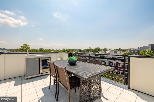 view of patio featuring a balcony, beverage cooler, and sink