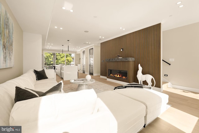 living room featuring light wood-type flooring and a large fireplace