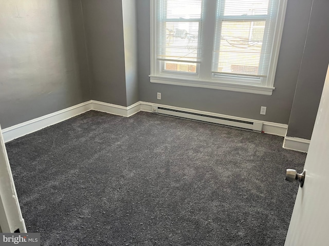 carpeted empty room with a baseboard heating unit