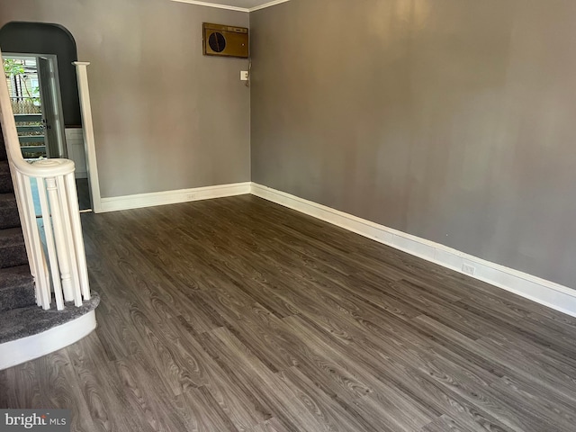 empty room featuring dark hardwood / wood-style floors and ornamental molding