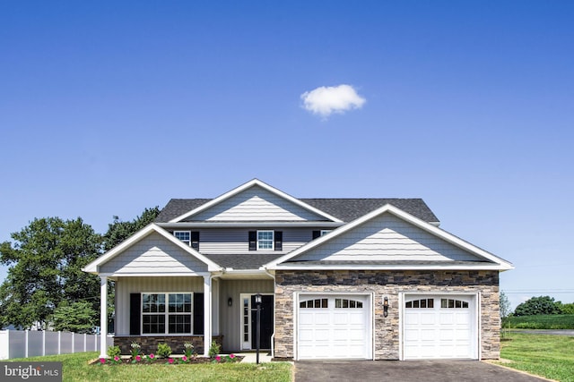 craftsman-style home featuring a front yard and a garage