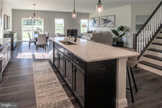 kitchen with dark hardwood / wood-style floors, a center island with sink, a healthy amount of sunlight, and sink