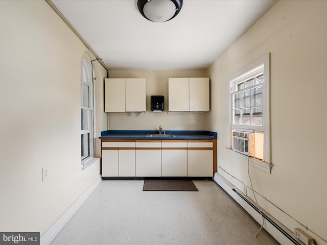 kitchen with cooling unit, sink, and baseboard heating