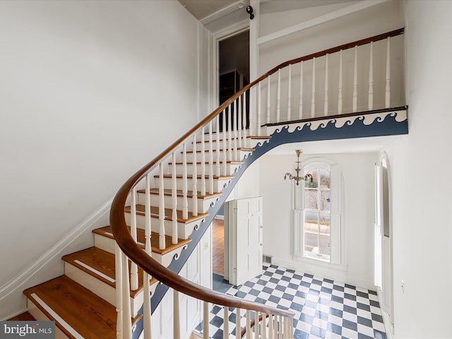 stairway featuring a chandelier