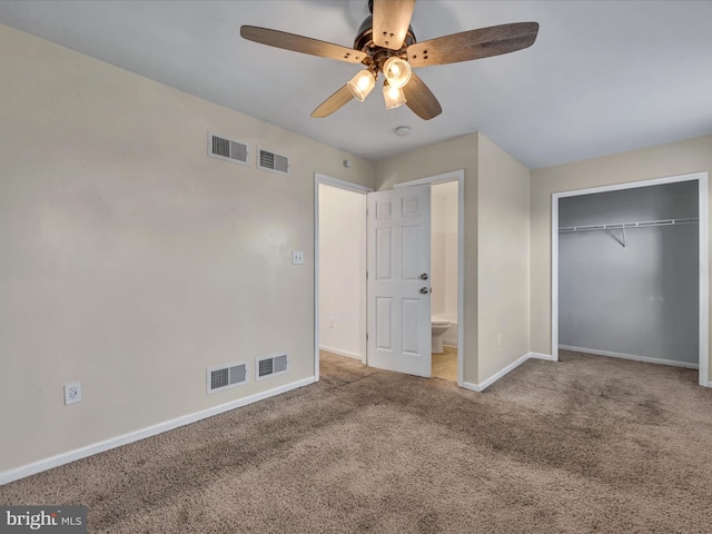 unfurnished bedroom featuring carpet flooring, a closet, ensuite bath, and ceiling fan