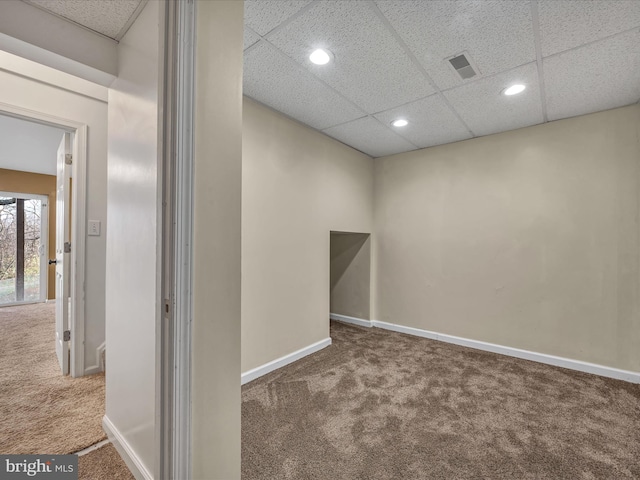 unfurnished room featuring carpet flooring and a drop ceiling