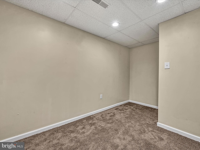 unfurnished room featuring carpet and a drop ceiling