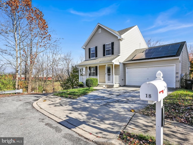 front facade with solar panels, a porch, and a garage