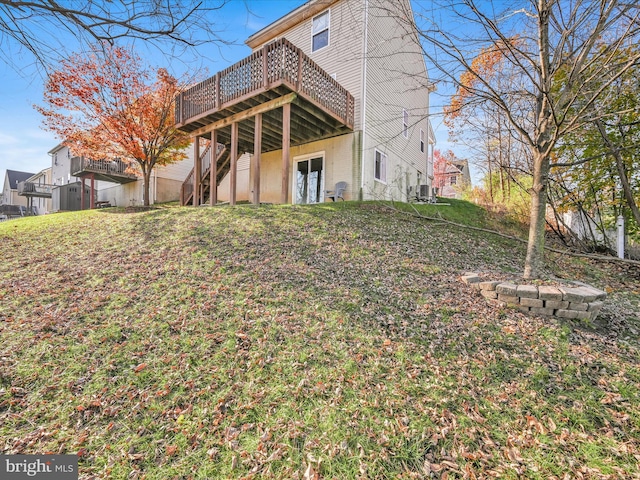 rear view of property featuring a yard and a wooden deck