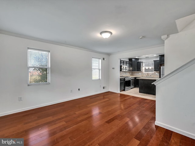 unfurnished living room featuring crown molding, dark wood-type flooring, and sink