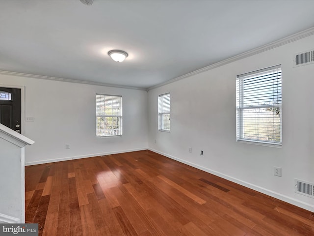 empty room featuring wood-type flooring and crown molding