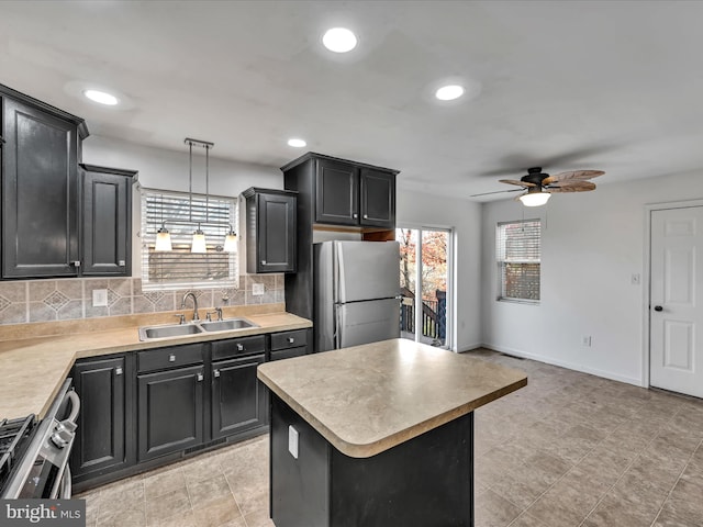 kitchen featuring ceiling fan, sink, pendant lighting, a center island, and stainless steel refrigerator