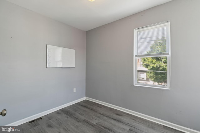 unfurnished room with dark wood-type flooring