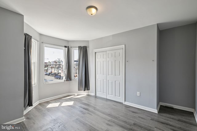 unfurnished bedroom with wood-type flooring and a closet