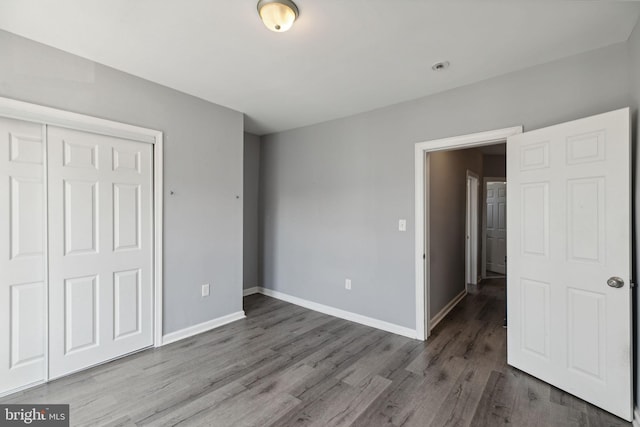 unfurnished bedroom with wood-type flooring and a closet