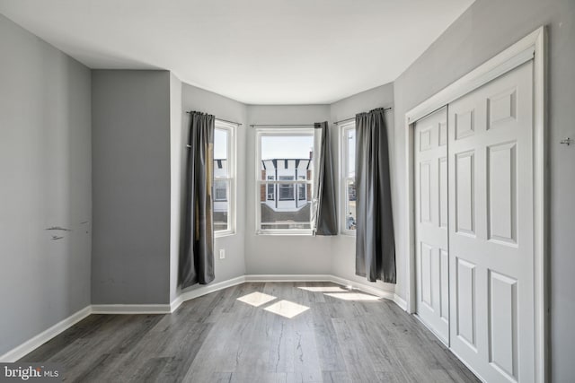 unfurnished bedroom featuring a closet and dark hardwood / wood-style flooring