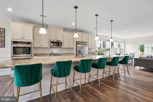 kitchen featuring pendant lighting, stainless steel appliances, and a spacious island