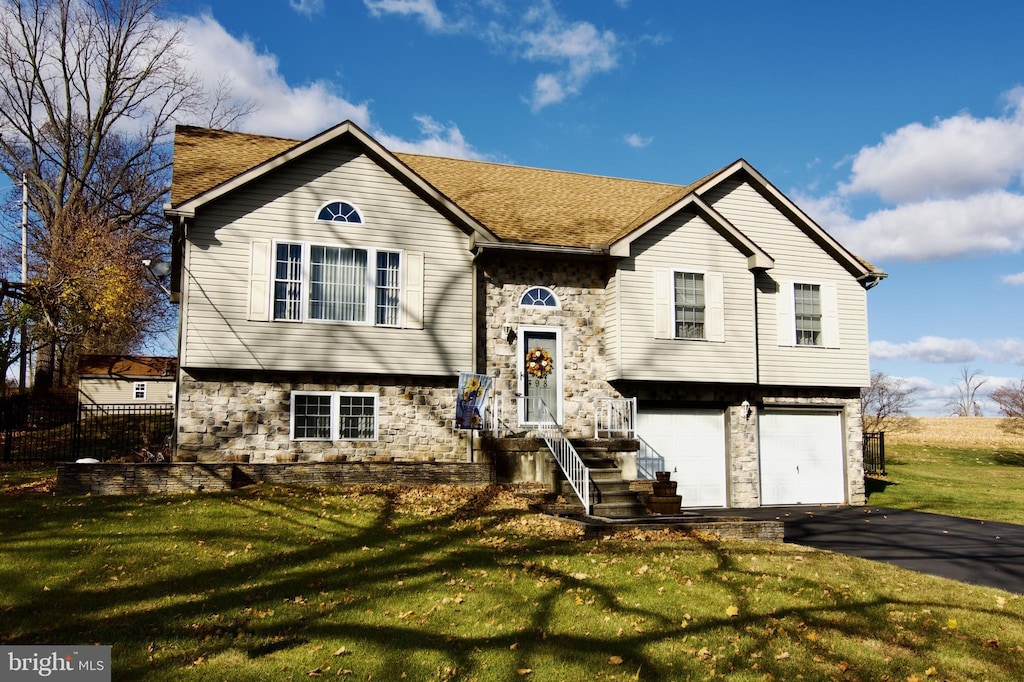 bi-level home featuring a front yard and a garage