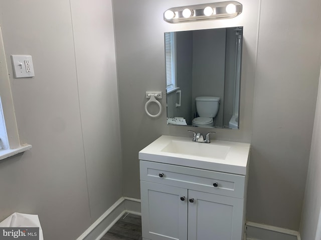 bathroom featuring hardwood / wood-style floors, vanity, and toilet