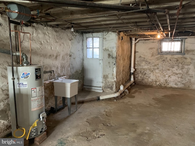 basement with sink, a healthy amount of sunlight, and gas water heater