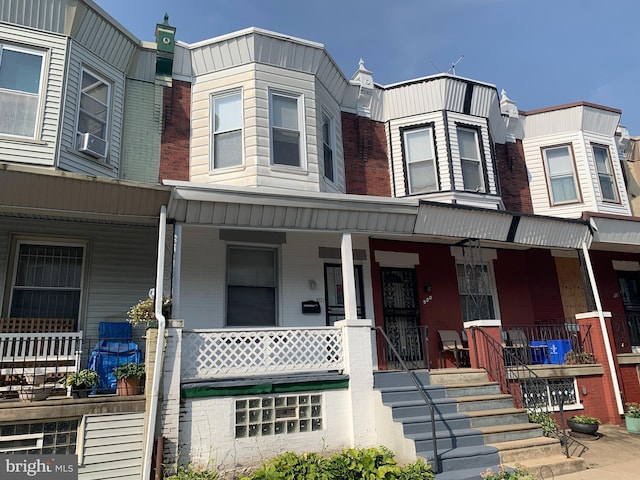 townhome / multi-family property featuring cooling unit and covered porch